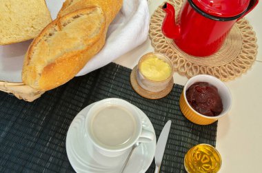 Sütlü kahve ve çeşitli yiyeceklerle kahvaltı masası. Brezilya