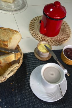 Sütlü kahve ve çeşitli yiyeceklerle kahvaltı masası. Brezilya