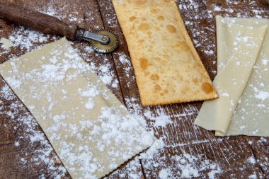 Kızarmış pastel, ya da İngilizce hamur ve ham pastel, kırsal ahşap masa üzerinde, hamur makasıyla. Sao Paulo şehri, Brezilya