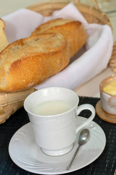 Ekmek, tereyağı ve bir fincan sütle kahvaltı masası. Brezilya