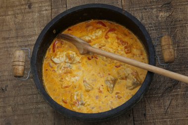 Balık güveci, veya Portekizce Moqueca de Peixe, tipik Brezilya yemeği, siyah taşın üzerinde kil bir tencerede. Sao Paulo, Brezilya