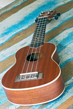 Ukulele, mavi çizgili rustik ahşap tahta üzerinde küçük bir Hawai gitar