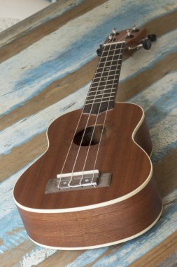 Ukulele, mavi çizgili rustik ahşap tahta üzerinde küçük bir Hawai gitar