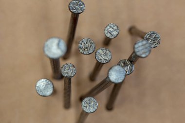 Farklı açılardan tahtaya çivilenmiş çivi grubu, soyut kompozisyonda.