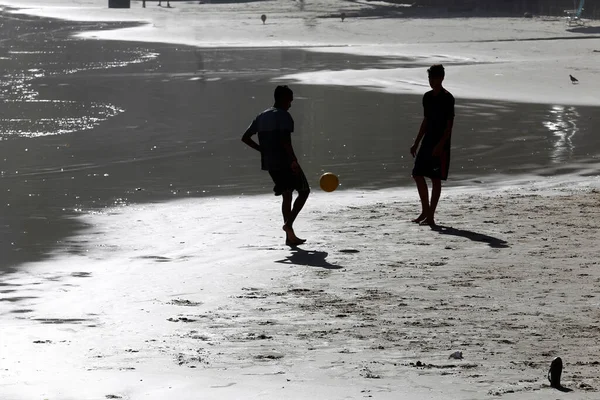 若い男性は夕暮れ時にビーチでサッカーをしている ブラジルのグアルジャ — ストック写真