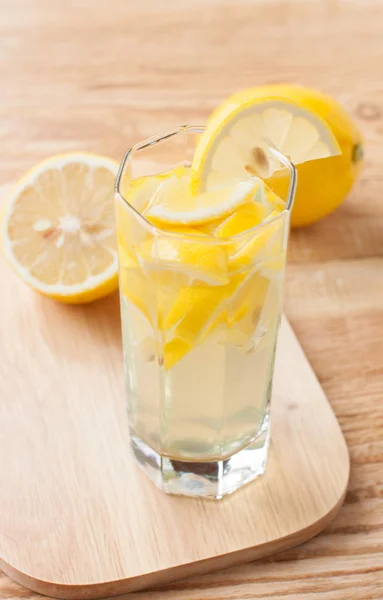 Boisson au citron dans un verre et citrons — Photo