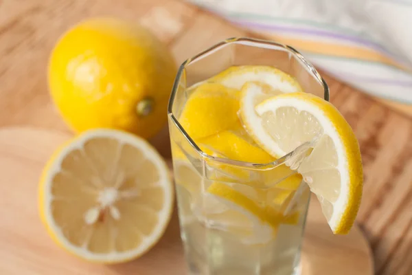Boisson au citron dans un verre et citrons — Photo