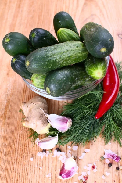 Cucumbers in a bowl, greens, garlic and spices for pickling. — Stock Photo, Image