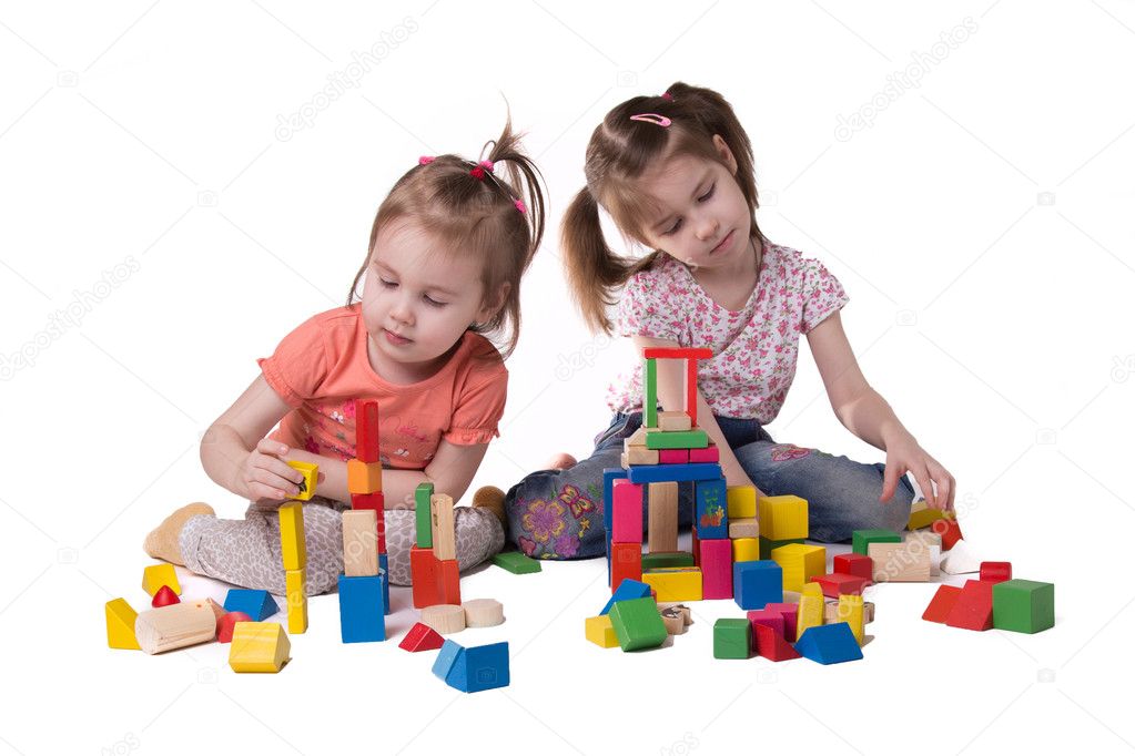  two girls playing with colorful wooden designer sitting