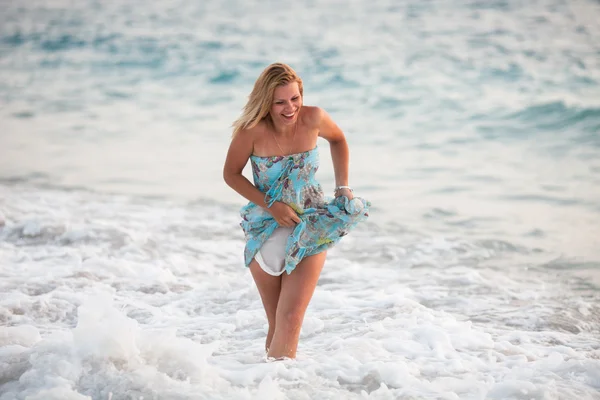 Mladá krásná žena stojící na pláži poblíž vlny Stock Obrázky