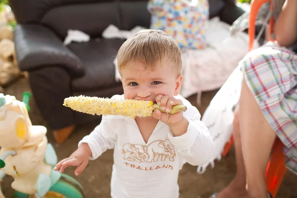 Dítě jíst vařené kukuřice Stock Obrázky