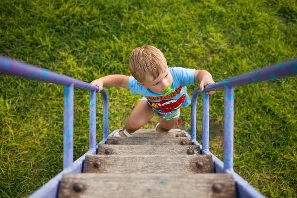 Happy little boy walking up on ladder — Stock Photo, Image