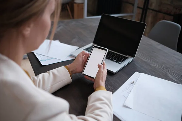 Крупный план женских рук с помощью ноутбука и смартфона в кофейне с белым макетом экрана, женские руки, печатающие на клавиатуре ноутбука, вид сбоку мужчины, пользующегося компьютером в кафе — стоковое фото