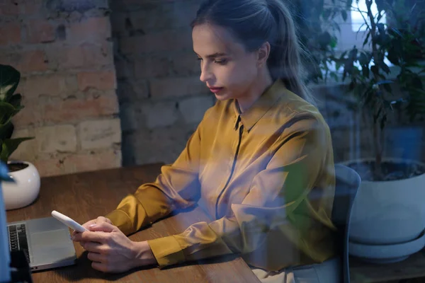 Счастливая деловая женщина разговаривает по мобильному телефону, анализируя документы в ноутбуке. — стоковое фото