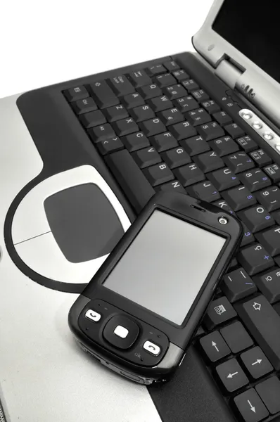 Mobilní na klávesnici notebooku — Stock fotografie