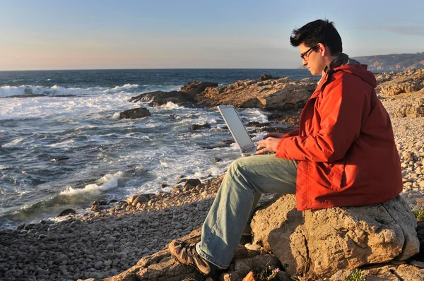 Молода людина на пляжі з ноутбуком — стокове фото