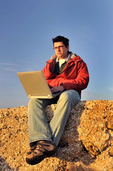 Hombre joven con portátil al aire libre — Foto de Stock