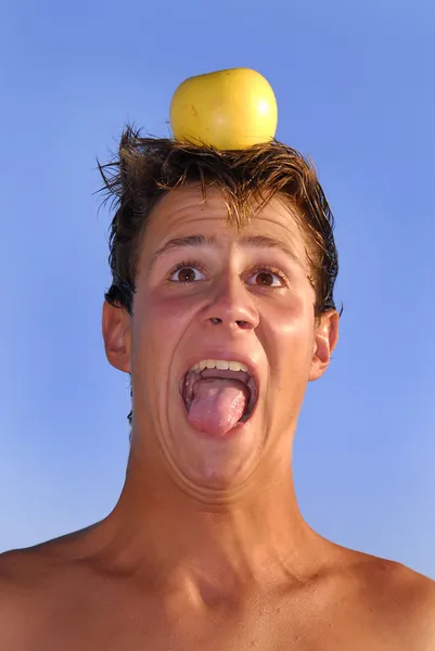 Rapaz com uma maçã na cabeça — Fotografia de Stock