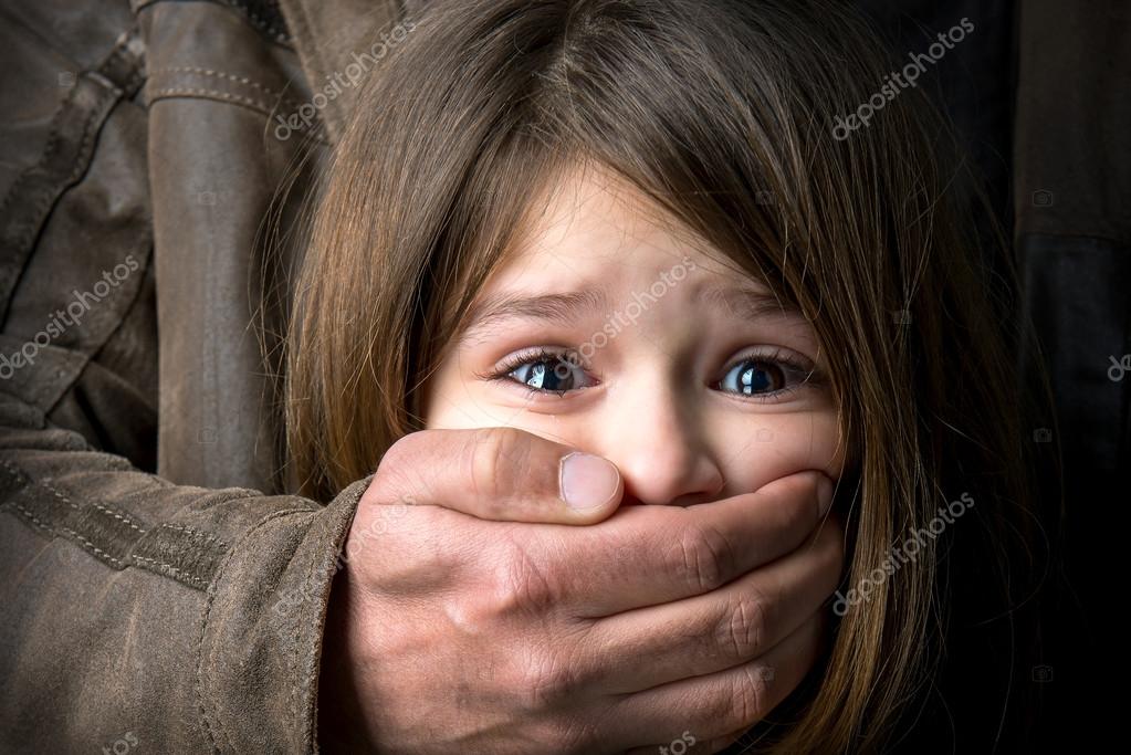 Tight cropped face of a scared young girl with hands covering