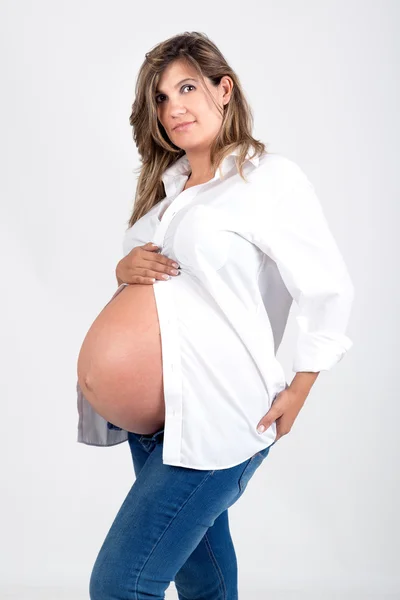 Těhotná žena v džínách — Stock fotografie