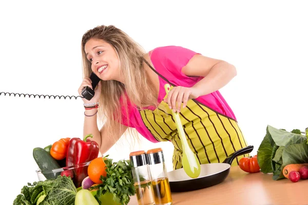 Femme cuisine et parle au téléphone — Photo