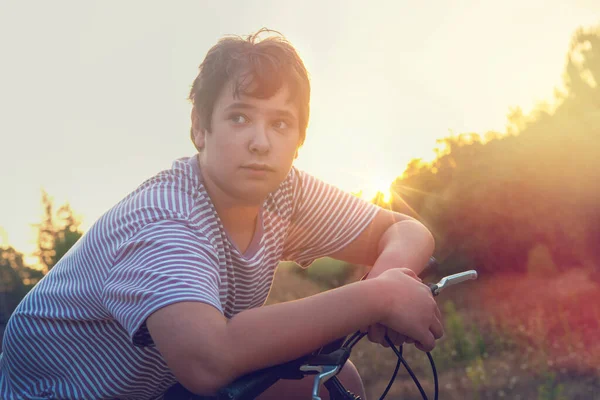 Ευτυχισμένο Αγόρι Ποζάρουν Ένα Ποδήλατο Έξω Στο Ηλιοβασίλεμα — Φωτογραφία Αρχείου