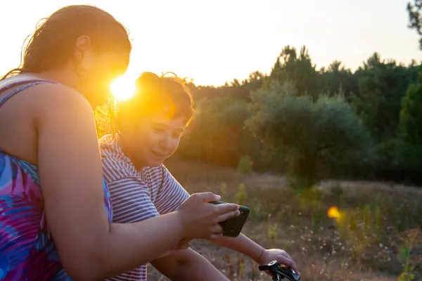 Young Woman Showing Video Photo Phone Boy Bicycle Sunset Outdoors — Stock Photo, Image