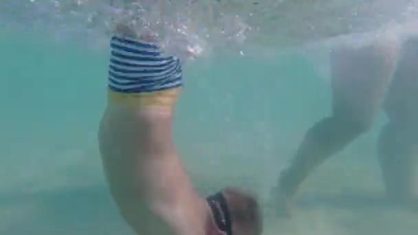 一个戴着水下面具的孩子学习游泳和潜水 那男孩潜入海里 — 图库视频影像