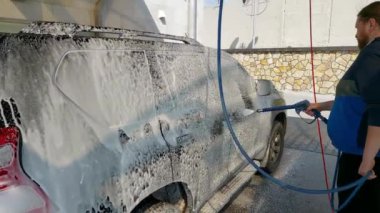 Kyiv, Ukrayna - Mart 2022: Bir adam araba yıkamada araba yıkar..