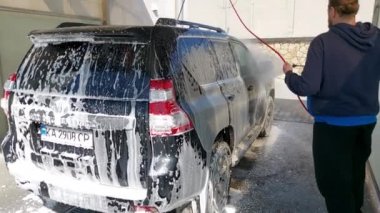 Kyiv, Ukrayna - Mart 2022: Bir adam araba yıkamada araba yıkar..