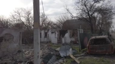 Velyka Dymerka, Kyiv bölgesi, Ukrayna - Nisan 2022: Ukrayna savaşı. Rus ordusunun bombardımanından sonra bir evin yıkıntıları ve havaya uçan bir araba dolusu sivil. Füzeden sonra araba ve ev hasar gördü.