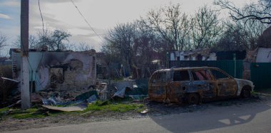 Velyka Dymerka, Kyiv bölgesi, Ukrayna - Nisan 2022: Ukrayna savaşı. Rus ordusunun bombardımanından sonra bir evin yıkıntıları ve havaya uçan bir araba dolusu sivil. Füzeden sonra araba ve ev hasar gördü.
