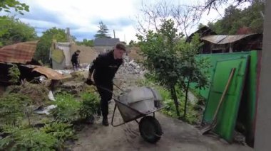 Gorenka, Kyiv region, Ukraine - July 2022: Local residents are clearing the rubble of a destroyed house. Consequences of the war between Russia and Ukraine. Destroyed houses after the bombing of the R