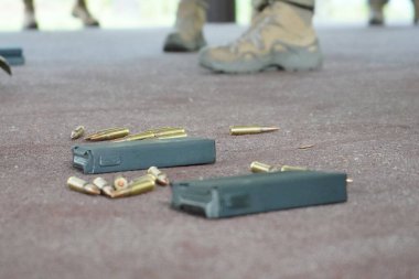 Poltava-Kharkiv region, Ukraine - August 2022: Ukrainian military man receives cartridges for a machine gun. A soldier of a volunteer formation of a territorial community inserts cartridges into a gun horn. Cartridges in the hands of a military soldi