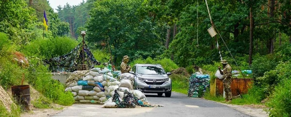 Poltava-Kharkiv region, Ukraine - August 2022: Ukrainian military is on duty at the checkpoint. Soldier of the volunteer formation of the territorial community on combat duty. Weapon in the hands of a military soldier.