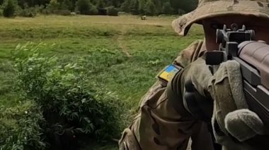 Poltava-Kharkiv region, Ukraine - August 2022: Ukrainian territorial defense fighter shoots from American M14 rifle. M14 rifle in the hands of a Ukrainian soldier. Shell casings are poured from firearms during firing.