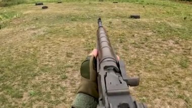 Poltava-Kharkiv region, Ukraine - August 2022: Ukrainian territorial defense fighter shoots from American M14 rifle. M14 rifle in the hands of a Ukrainian soldier. Shell casings are poured from firearms during firing.