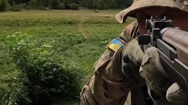 Poltava-Kharkiv region, Ukraine - August 2022: Ukrainian territorial defense fighter shoots from American M14 rifle. M14 rifle in the hands of a Ukrainian soldier. Shell casings are poured from firearms during firing.