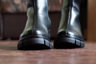 Yüksek siyah çizmeli kız evdeki eski kirli zeminde, kadın ayakkabıları, yerde ayaklar, ahşap zeminde ayakkabılar