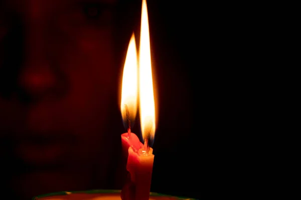 속에서 촛불을 밝히며 촛불을 밝히는 모습을 배경으로 소녀의 — 스톡 사진