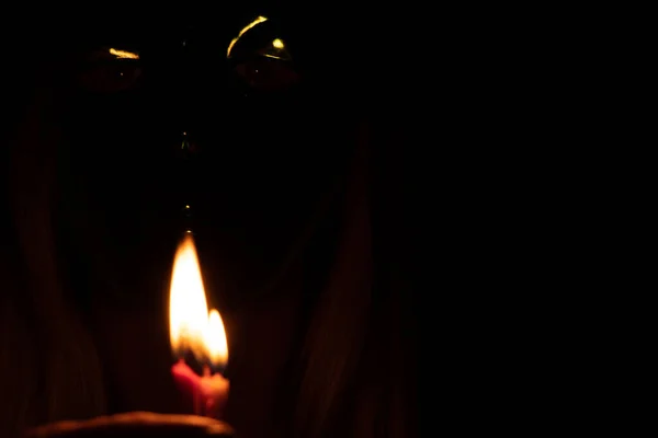 face of a girl in a carnival mask in the dark goats flame candles, a man in a mask, carnival mask