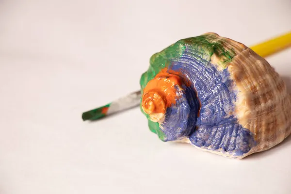 Seashell Painted Multi Colored Paints Lies Next Brush White Background — Stock Photo, Image