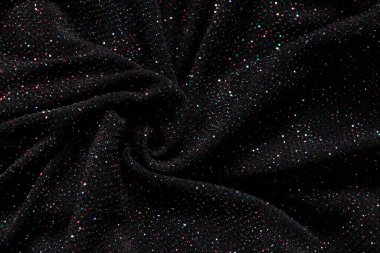 Arkaplan olarak çok renkli pulları olan siyah buruşuk kumaş, arkaplan için parlak kumaş