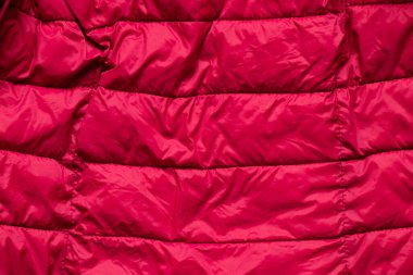 Arka plan olarak kırmızı kabarık kadın ceketi, arka plan olarak kırmızı kumaş, arka plan olarak da kış ceketi.