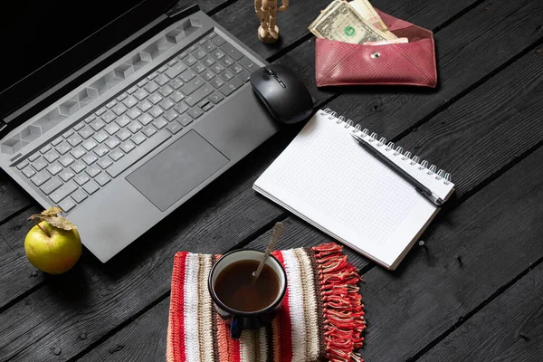 有咖啡钱的黑色笔记本电脑笔记本电脑杯放在工作的黑色木制桌子上 笔记本电脑在工作期间放在工作台上 创造性的过程 自由职业工作场所 — 图库照片