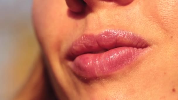 ปากของผู้หญิง ริมฝีปากใกล้ชิดของเด็กสาวที่อยู่กลางแจ้งในดวงอาทิตย์ — วีดีโอสต็อก