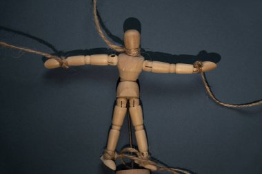 Ahşap adam izole bir arka planda, bir adamın eline bağlı, insanları manipüle etmek, kölelik, özgür irade, insanlar üzerinde güç.