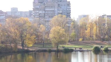 Ukrayna 'nın Dnipro şehrinde bir yerleşim bölgesi, parklarda çok katlı bir bina sonbaharda suyla bir taş ocağı aldılar, sonbaharda güneşin altında bir yerleşim bölgesi.