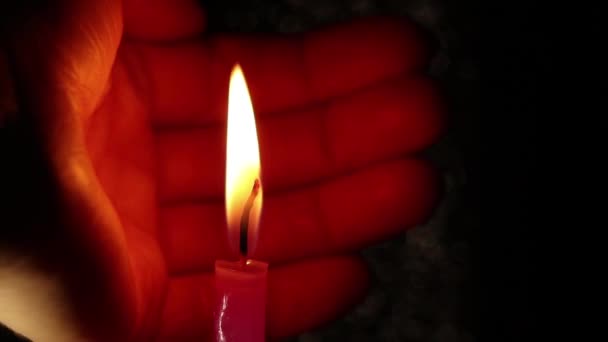 女人的手在黑暗中举起蜡烛的火焰 蜡烛的火焰举起它的手 宗教和节日 — 图库视频影像