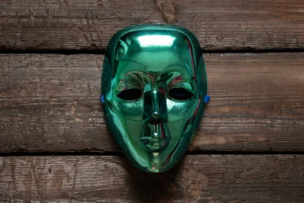 绿色的塑料面具放在木板上 狂欢节的面具放在桌子上 — 图库照片